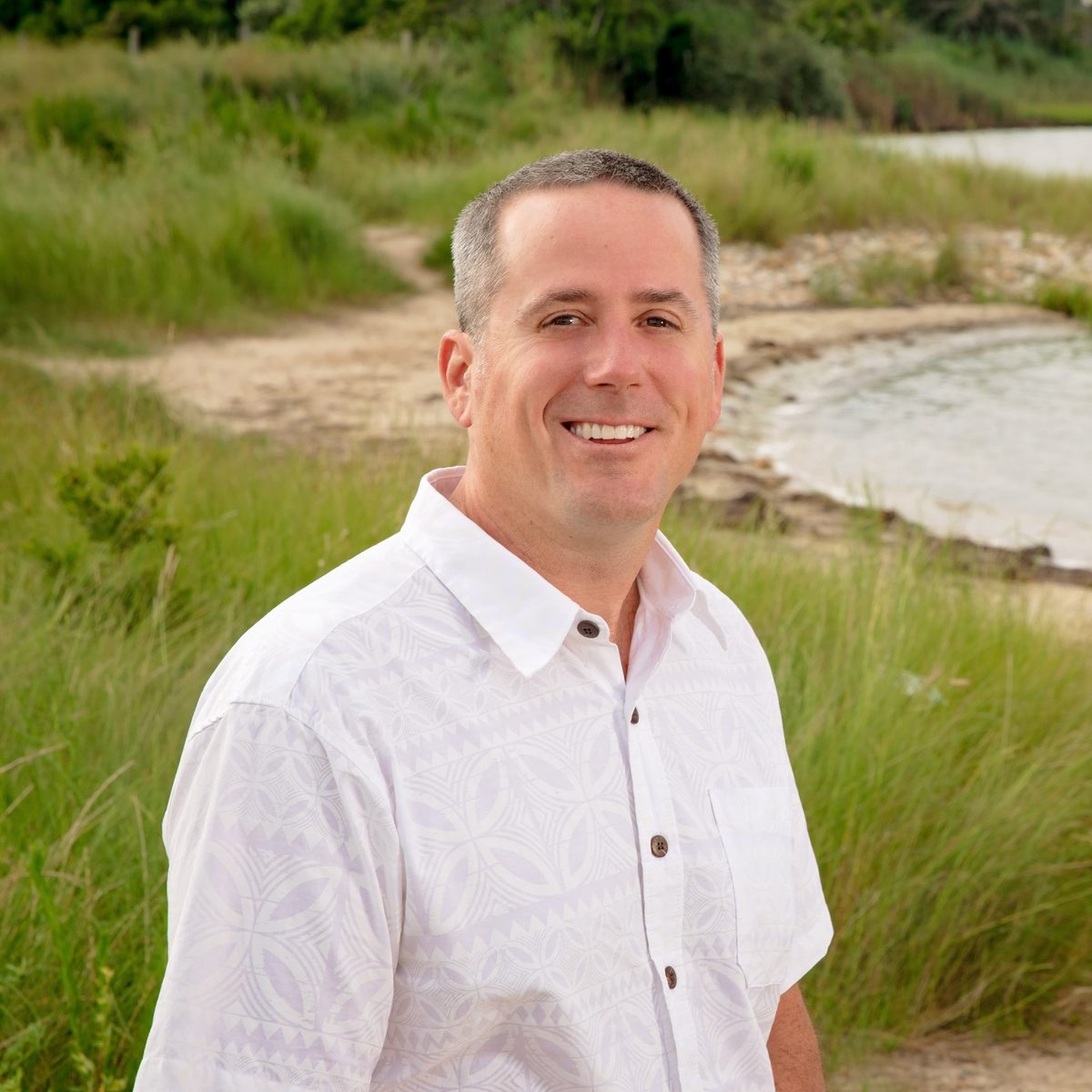 Brian Foley smiling by the water's edge in coastal Maryland